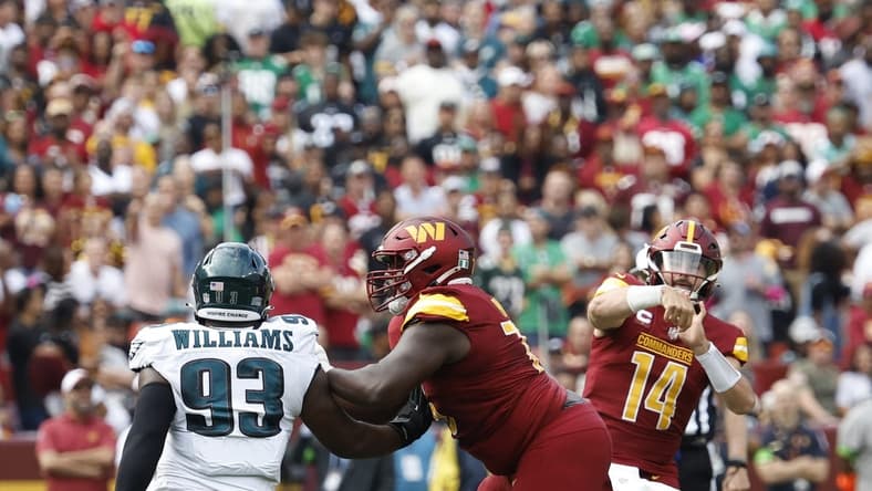 Washington Commanders quarterback Sam Howell (14) throws a touchdown pass as Philadelphia Eagles defensive tackle Milton Williams (93) defends during the first quarter at FedExField. Mandatory Credit: Geoff Burke-USA TODAY Sports