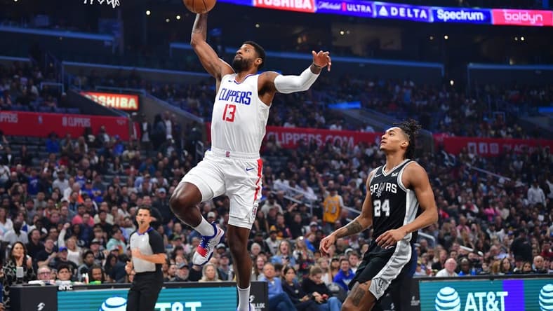 Oct 29, 2023; Los Angeles, California, USA; Los Angeles Clippers forward Paul George (13) scores a basket ahead of San Antonio Spurs guard Devin Vassell (24) during the first half at Crypto.com Arena. Mandatory Credit: Gary A. Vasquez-USA TODAY Sports
