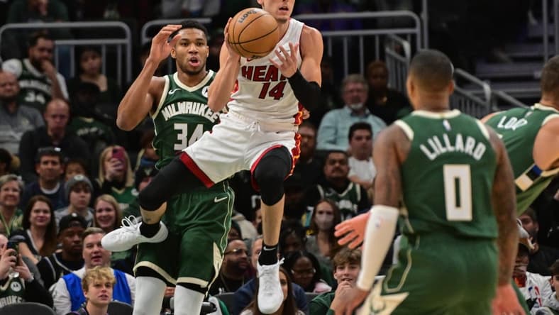 Oct 30, 2023; Milwaukee, Wisconsin, USA; Miami Heat guard Tyler Herro (14) grabs a rebound against Milwaukee Bucks forward Giannis Antetokounmpo (34) in the first quarter at Fiserv Forum. Mandatory Credit: Benny Sieu-USA TODAY Sports