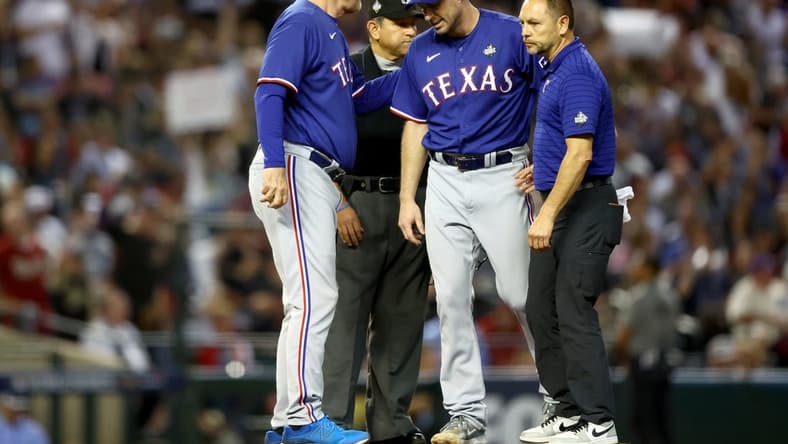Oct 30, 2023; Phoenix, AZ, USA; Texas Rangers pitcher Max Scherzer (31) talks to manager Bruce Bochy (15) and a trainer before leaving the game in the fourth inning in game three of the 2023 World Series against the Arizona Diamondbacks at Chase Field. Mandatory Credit: Mark J. Rebilas-USA TODAY Sports