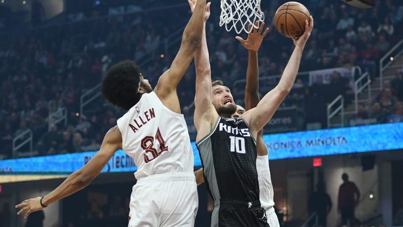 Dec 9, 2022; Cleveland, Ohio, USA; Sacramento Kings forward Domantas Sabonis (10) drives to the basket against Cleveland Cavaliers center Jarrett Allen (31) and forward Evan Mobley (4) during the first half at Rocket Mortgage FieldHouse. Mandatory Credit: Ken Blaze-USA TODAY Sports