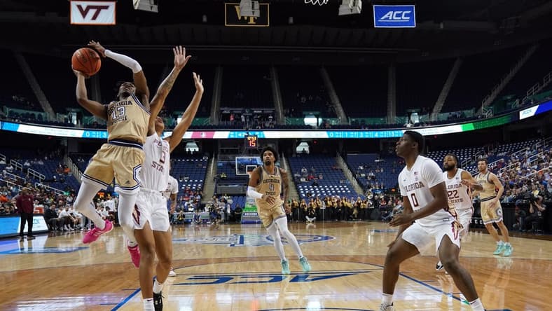 Mar 7, 2023; Greensboro, NC, USA; Georgia Tech Yellow Jackets guard Miles Kelly (13) goes up for a shot against Florida State Seminoles forward Cam Corhen (3) during the second half of the first round of the ACC tournament at Greensboro Coliseum. Mandatory Credit: John David Mercer-USA TODAY Sports