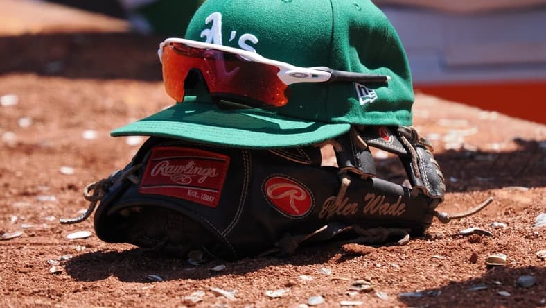 Jun 29, 2023; Oakland, California, USA; An Oakland Athletics hat on top of a glove during the eighth inning at Oakland-Alameda County Coliseum. Mandatory Credit: Kelley L Cox-USA TODAY Sports