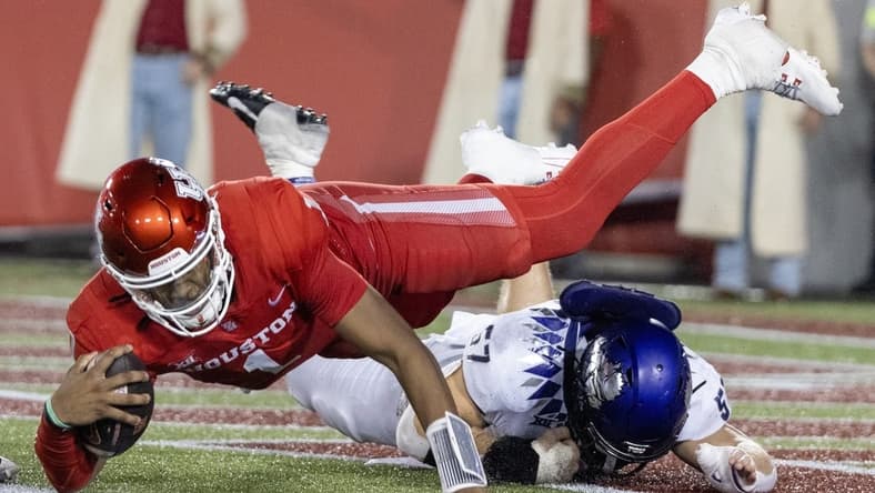 Sep 16, 2023; Houston, Texas, USA; Houston Cougars wide receiver Samuel Brown (4) is tackled by TCU Horned Frogs linebacker Johnny Hodges (57) on the one yard line in the second half at TDECU Stadium. Mandatory Credit: Thomas Shea-USA TODAY Sports