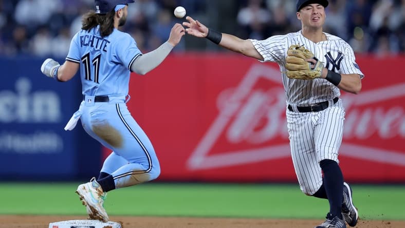 Sep 19, 2023; Bronx, New York, USA; New York Yankees shortstop Anthony Volpe (11) forces Toronto Blue Jays shortstop Bo Bichette (11) out at second and throws to first to complete a double play on a ball hit by designated hitter Vladimir Guerrero Jr. (not pictured) during the first inning at Yankee Stadium. Mandatory Credit: Brad Penner-USA TODAY Sports