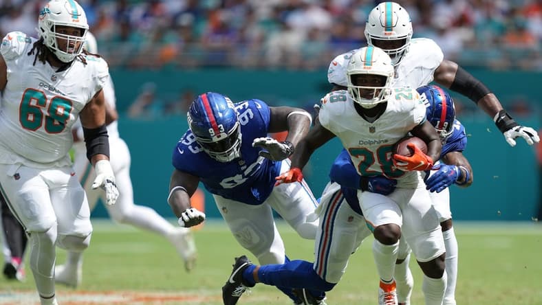 Miami Dolphins running back De'Von Achane (28) breaks free for a gain as New York Giants safety Isaiah Simmons (19) closes in on the play during the first half of an NFL game at Hard Rock Stadium in Miami Gardens, October 8, 2023.