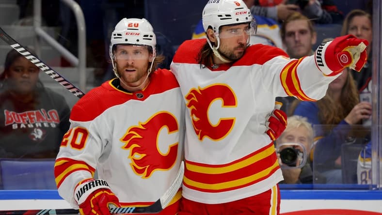 Oct 19, 2023; Buffalo, New York, USA; Calgary Flames center Blake Coleman (20) celebrates his goal with defenseman Chris Tanev (8) during the third period against the Buffalo Sabres at KeyBank Center. Mandatory Credit: Timothy T. Ludwig-USA TODAY Sports