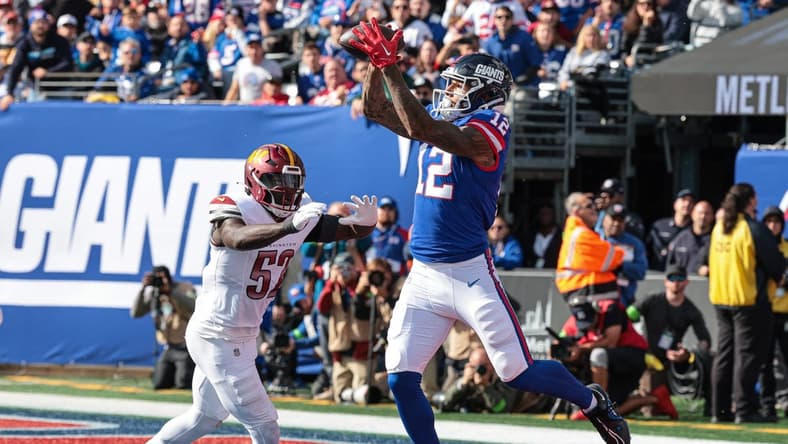 Oct 22, 2023; East Rutherford, New Jersey, USA; New York Giants tight end Darren Waller (12) catches a touchdown pass during the first half in front of Washington Commanders linebacker Jamin Davis (52) at MetLife Stadium. Mandatory Credit: Vincent Carchietta-USA TODAY Sports