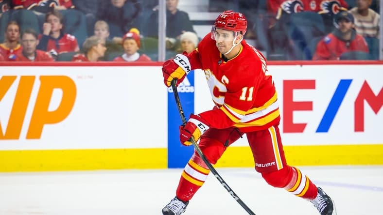 Oct 24, 2023; Calgary, Alberta, CAN; Calgary Flames center Mikael Backlund (11) shoot the puck against the New York Rangers during the second period at Scotiabank Saddledome. Mandatory Credit: Sergei Belski-USA TODAY Sports