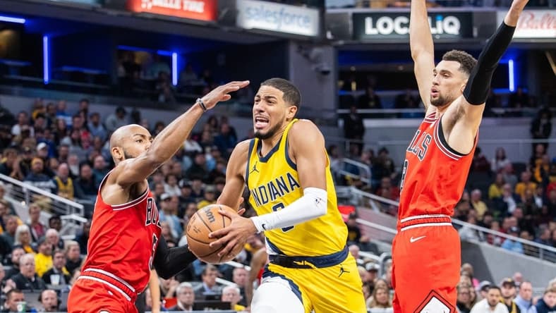 Oct 30, 2023; Indianapolis, Indiana, USA; Indiana Pacers guard Tyrese Haliburton (0) dribbles the ball while Chicago Bulls guard Jevon Carter (5) and guard Zach LaVine (8) defend in the second half at Gainbridge Fieldhouse. Mandatory Credit: Trevor Ruszkowski-USA TODAY Sports