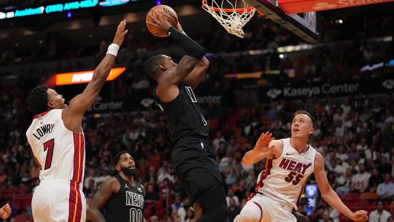 Nov 1, 2023; Miami, Florida, USA; Brooklyn Nets guard Lonnie Walker IV (8) puts up a shot between Miami Heat guard Kyle Lowry (7) and forward Duncan Robinson (55) during the first half at Kaseya Center. Mandatory Credit: Jasen Vinlove-USA TODAY Sports