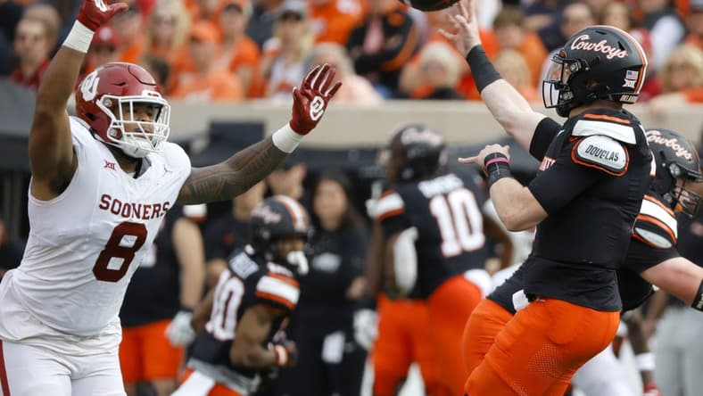 Nov 4, 2023; Stillwater, Oklahoma, USA; Oklahoma State Cowboys quarterback Alan Bowman (7) throws a pass over Oklahoma Sooners defensive lineman Jonah Laulu (8) during a game at Boone Pickens Stadium. Mandatory Credit: Bryan Terry-USA TODAY Sports