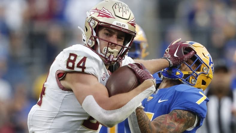 Nov 4, 2023; Pittsburgh, Pennsylvania, USA;  Florida State Seminoles tight end Kyle Morlock (84) stiff arms Pittsburgh Panthers defensive back Javon McIntyre (7) after a catch during the second quarter at Acrisure Stadium. Mandatory Credit: Charles LeClaire-USA TODAY Sports