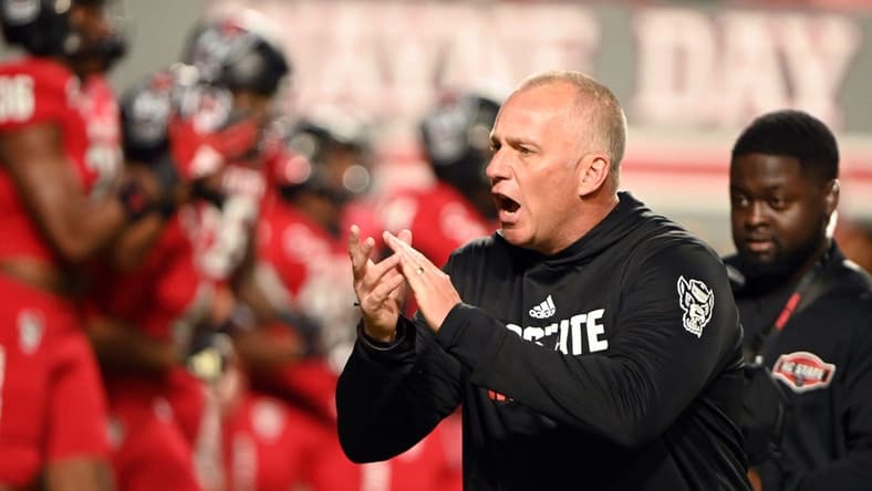 Nov 4, 2023; Raleigh, North Carolina, USA;  North Carolina State Wolfpack head coach Dave Doeren encourages his team as they warm up prior to a game against the Miami Hurricanes at Carter-Finley Stadium. Mandatory Credit: Rob Kinnan-USA TODAY Sports