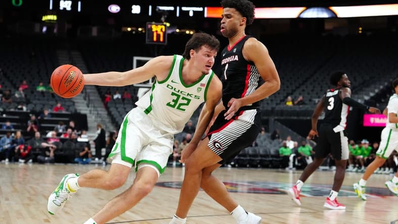 Nov 6, 2023; Las Vegas, Nevada, USA; Oregon Ducks center Nate Bittle (32) dribbles against Georgia Bulldogs guard Jabri Abdur-Rahim (1) during the first half at T-Mobile Arena. Mandatory Credit: Stephen R. Sylvanie-USA TODAY Sports