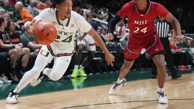 Nov 6, 2023; Coral Gables, Florida, USA; Miami (Fl) Hurricanes guard Nijel Pack (24) drives past N.J.I.T Highlanders guard Mekhi Gray (24) in the first half at Watsco Center. Mandatory Credit: Jim Rassol-USA TODAY Sports