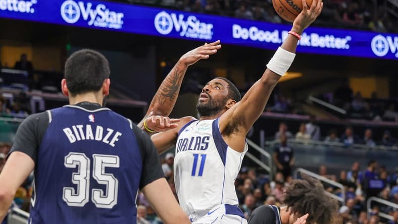 Nov 6, 2023; Orlando, Florida, USA; Dallas Mavericks guard Kyrie Irving (11) drives to the basket against Orlando Magic center Goga Bitadze (35) during the first quarter at Amway Center. Mandatory Credit: Mike Watters-USA TODAY Sports