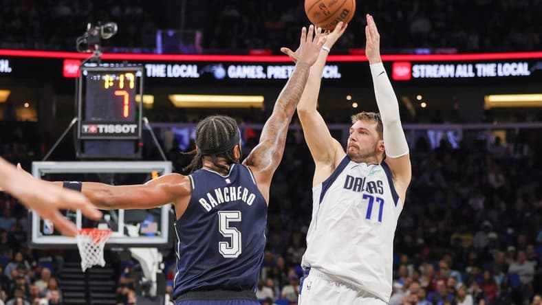 Nov 6, 2023; Orlando, Florida, USA; Dallas Mavericks guard Luka Doncic (77) shoots the ball against Orlando Magic forward Paolo Banchero (5) during the second quarter at Amway Center. Mandatory Credit: Mike Watters-USA TODAY Sports