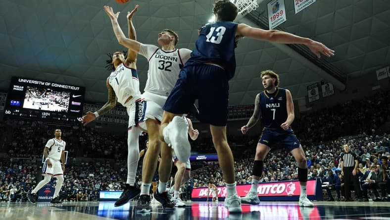 Nov 6, 2023; Storrs, Connecticut, USA; UConn Huskies center Donovan Clingan (32) and guard Solomon Ball (1) defend against Northern Arizona Lumberjacks forward Rockwell Reynolds (13) in the second half at Harry A. Gampel Pavilion. Mandatory Credit: David Butler II-USA TODAY Sports