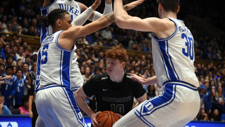 Nov 6, 2023; Durham, North Carolina, USA; Dartmouth Big Green guard Ryan Cornish (10) controls the ball as Duke Blue Devils center Kyle Filipowski(30) and guard Tyrese Proctor(5) defend during the first half at Cameron Indoor Stadium. Mandatory Credit: Rob Kinnan-USA TODAY Sports
