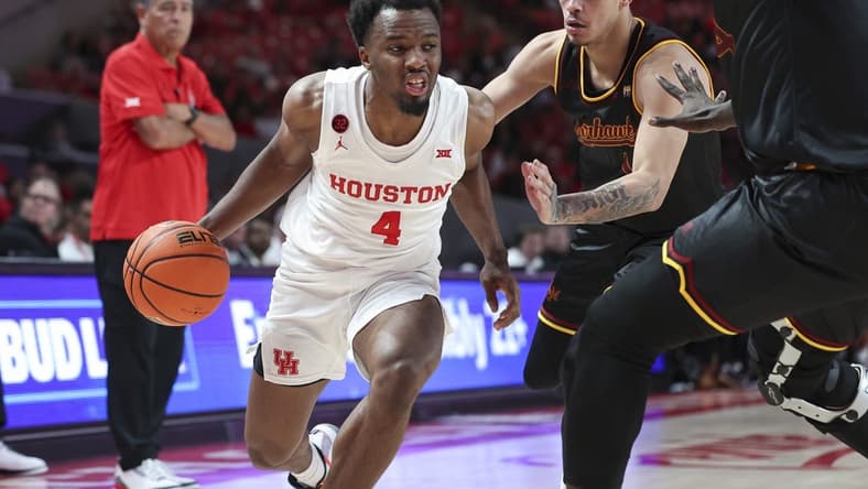 Nov 6, 2023; Houston, Texas, USA; Houston Cougars guard LJ Cryer (4) drives with the ball as Louisiana Monroe Warhawks guard Savion Gallion (1) defends during the second half at Fertitta Center. Mandatory Credit: Troy Taormina-USA TODAY Sports