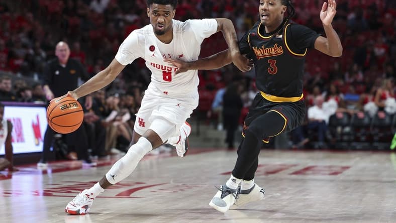 Nov 6, 2023; Houston, Texas, USA; Houston Cougars guard Mylik Wilson (8) controls the ball as Louisiana Monroe Warhawks guard Tyreke Locure (3) defends during the second half at Fertitta Center. Mandatory Credit: Troy Taormina-USA TODAY Sports