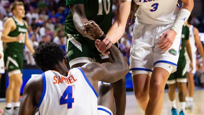 Florida Gators center Micah Handlogten (3) helps teammate Florida Gators forward Tyrese Samuel (4) up off the court. The Florida men   s basketball team hosted the Loyola Greyhounds at Exactech Arena at the Stephen C. O   Connell Center in Gainesville, FL on Monday, November 6, 2023 in the season opener. Gators lead 42-30 at the half. [Doug Engle/Ocala Star Banner]