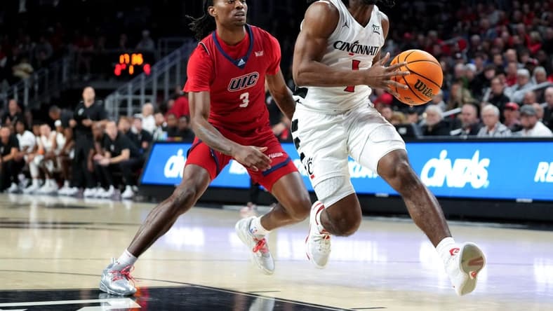 Cincinnati Bearcats guard Day Day Thomas (1) drives to the basket as Illinois-Chicago Flames guard CJ Jones (3) defends in the first half of a men   s college basketball game between the Illinois-Chicago Flames and the Cincinnati Bearcats, Monday, Nov. 6, 2023, at Fifth Third Arena in Cincinnati.