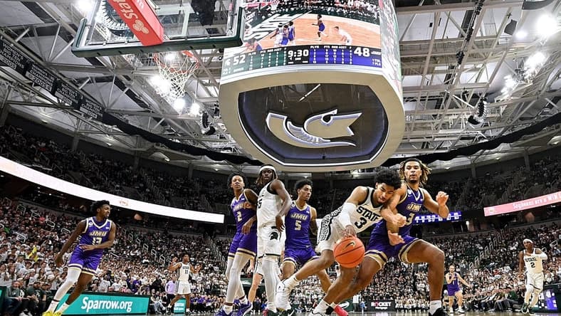 Nov 6, 2023; East Lansing, Michigan, USA; Michigan State Spartans guard Jaden Akins (3) battles with James Madison Dukes forward T.J. Bickerstaff (3) for a loose ball at Jack Breslin Student Events Center. Mandatory Credit: Dale Young-USA TODAY Sports