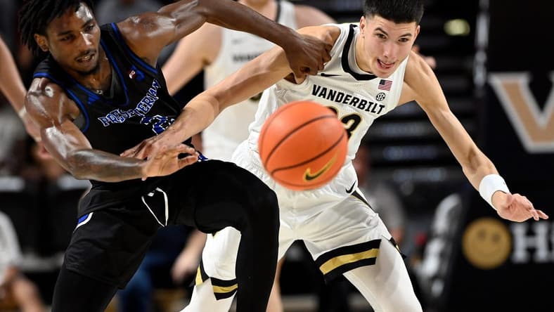 Presbyterian guard Samage Teel, left, and Vanderbilt guard Jason Rivera-Torres (23) battle to get a loose ball during the first half of an NCAA college basketball game Tuesday, Nov. 7, 2023, in Nashville, Tenn.