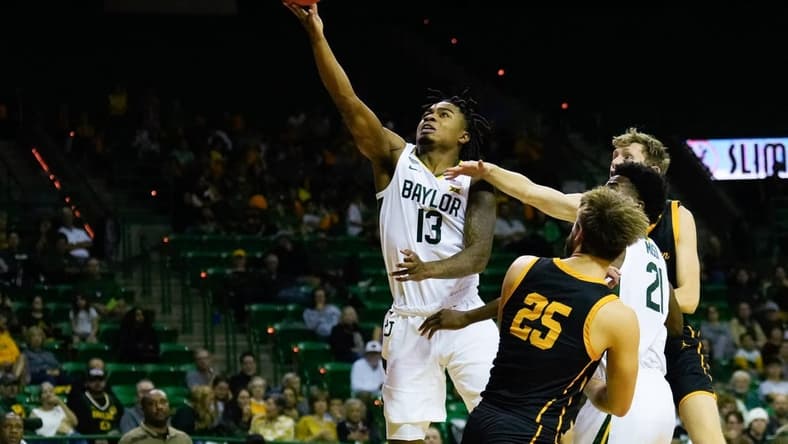 Nov 9, 2023; Waco, Texas, USA;  Baylor Bears guard Langston Love (13) scores a basket against John Brown Golden Eagles forward Lukas Gabani (25) during the second half at Ferrell Center. Mandatory Credit: Chris Jones-USA TODAY Sports
