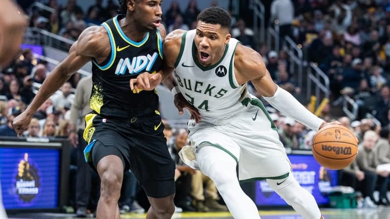 Nov 9, 2023; Indianapolis, Indiana, USA; Milwaukee Bucks forward Giannis Antetokounmpo (34) dribbles the ball while Indiana Pacers forward Aaron Nesmith (23) defends in the first quarter at Gainbridge Fieldhouse. Mandatory Credit: Trevor Ruszkowski-USA TODAY Sports