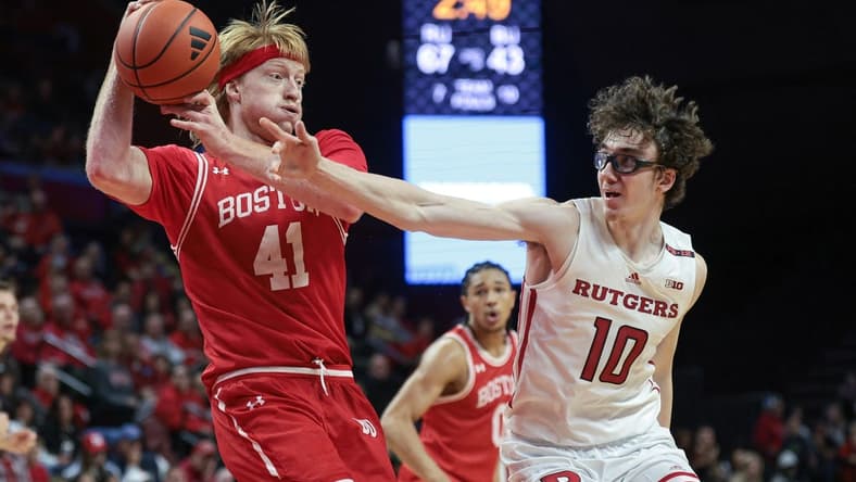 Nov 10, 2023; Piscataway, New Jersey, USA; Boston University Terriers forward Otto Landrum (41) grabs the ball in front of Rutgers Scarlet Knights guard Gavin Griffiths (10) during the second half at Jersey Mike's Arena. Mandatory Credit: Vincent Carchietta-USA TODAY Sports