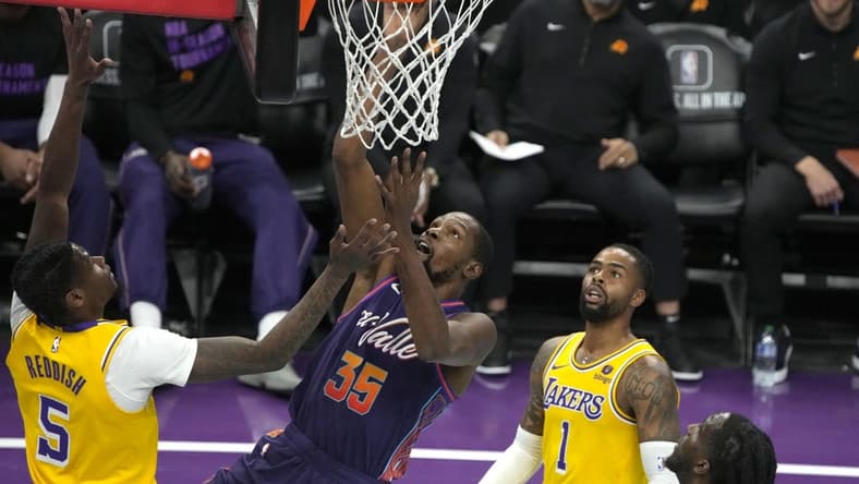 Nov 10, 2023; Phoenix, Arizona, USA; Phoenix Suns forward Kevin Durant (35) scores between Los Angeles Lakers forward Cam Reddish (5) and guard D'Angelo Russell (1) in the first half at Footprint Center. Mandatory Credit: Rick Scuteri-USA TODAY Sports