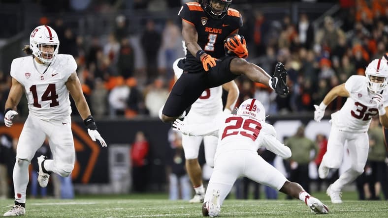 Nov 11, 2023; Corvallis, Oregon, USA; Oregon State Beavers running back Deshaun Fenwick (1) jumps over Stanford Cardinal corner back Terian Williams (29) during the second half at Reser Stadium. Mandatory Credit: Soobum Im-USA TODAY Sports