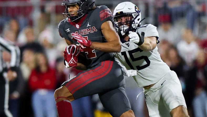 Nov 11, 2023; Norman, Oklahoma, USA;  Oklahoma Sooners wide receiver Nic Anderson (4) runs with the ball as West Virginia Mountaineers linebacker Ben Cutter (15) defends during the first quarter at Gaylord Family-Oklahoma Memorial Stadium. Mandatory Credit: Kevin Jairaj-USA TODAY Sports