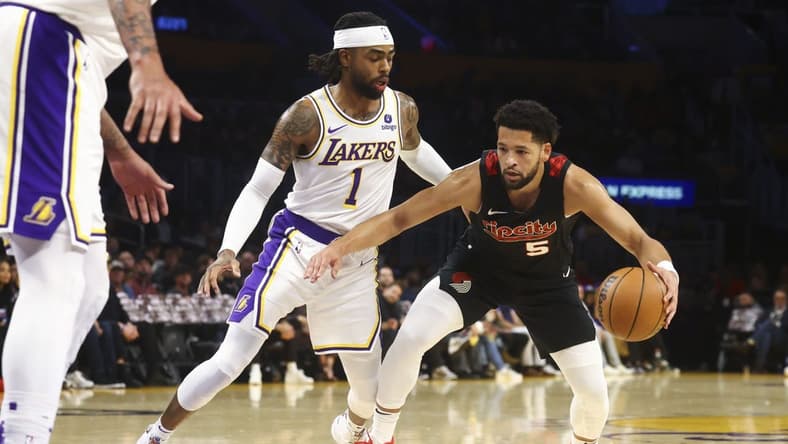 Nov 12, 2023; Los Angeles, California, USA; Portland Trail Blazers guard Skylar Mays (5) drives against the Los Angeles Lakers guard D'Angelo Russell (1) during the first half of a game at Crypto.com Arena. Mandatory Credit: Jessica Alcheh-USA TODAY Sports