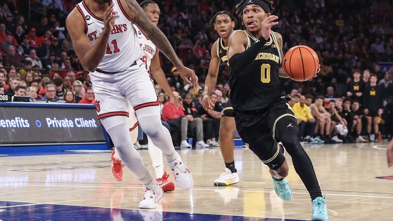Nov 13, 2023; New York, New York, USA; Michigan Wolverines guard Dug McDaniel (0) drives past St. John's Red Storm center Joel Soriano (11) in the first half at Madison Square Garden. Mandatory Credit: Wendell Cruz-USA TODAY Sports