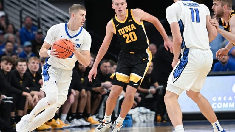 Nov 14, 2023; Omaha, Nebraska, USA; Creighton Bluejays guard Baylor Scheierman (55) drives against Iowa Hawkeyes forward Payton Sandfort (20) in the first half at CHI Health Center Omaha. Mandatory Credit: Steven Branscombe-USA TODAY Sports