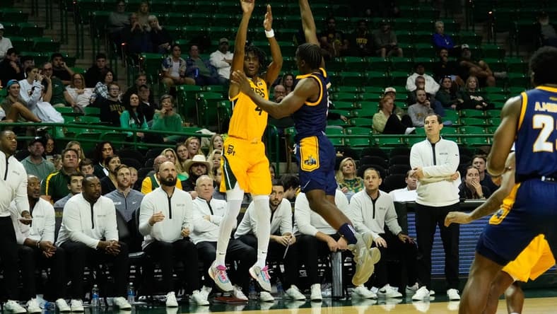 Nov 14, 2023; Waco, Texas, USA; Baylor Bears guard Ja'Kobe Walter (4) makes a three point shot against UMKC Kangaroos guard Jayson Petty (1) during the second half at Ferrell Center. Mandatory Credit: Chris Jones-USA TODAY Sports