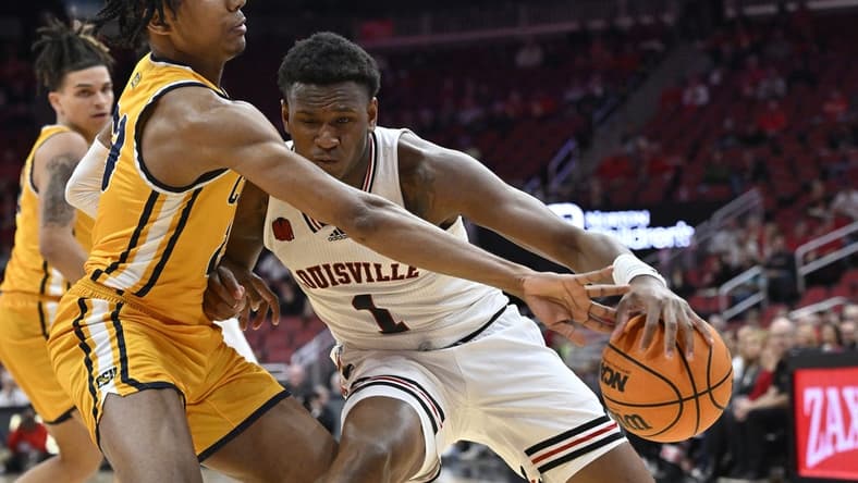 Nov 15, 2023; Louisville, Kentucky, USA; Coppin State Eagles guard Camaren Sparrow (23) pressures the dribble of Louisville Cardinals guard Curtis Williams (1) during the first half at KFC Yum! Center. Mandatory Credit: Jamie Rhodes-USA TODAY Sports