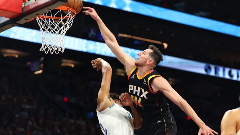 Nov 15, 2023; Phoenix, Arizona, USA; Phoenix Suns forward Drew Eubanks (right) slam dunks the ball against Minnesota Timberwolves center Karl-Anthony Towns in the first half at Footprint Center. Mandatory Credit: Mark J. Rebilas-USA TODAY Sports