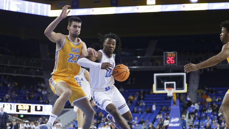 Nov 15, 2023; Los Angeles, California, USA; UCLA guard Sebastian Mack (12) drives the ball against Long Island University forward Nikola Djapa (23) during the first half at Pauley Pavilion presented by Wescom. Mandatory Credit: Yannick Peterhans-USA TODAY Sports