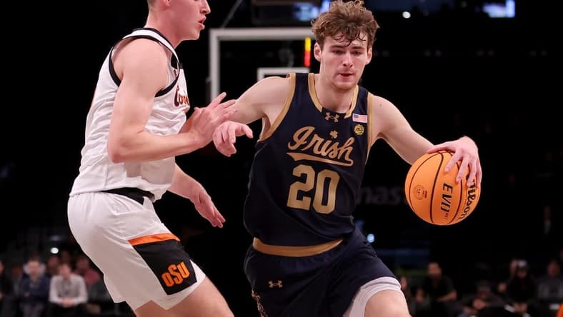 Nov 17, 2023; Brookyln, NY, USA; Notre Dame Fighting Irish guard J.R. Konieczny (20) controls the ball against Oklahoma State Cowboys guard Connor Dow (13) during the first half at Barclays Center. Mandatory Credit: Brad Penner-USA TODAY Sports