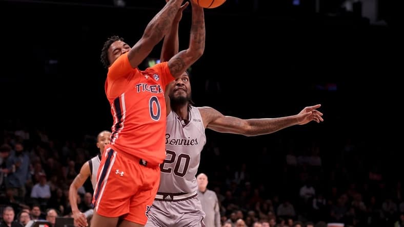 Nov 17, 2023; Brookyln, NY, USA; Auburn Tigers guard K.D. Johnson (0) grabs a rebound against St. Bonaventure Bonnies center Noel Brown (20) during the first half at Barclays Center. Mandatory Credit: Brad Penner-USA TODAY Sports