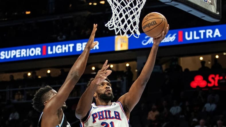 Nov 17, 2023; Atlanta, Georgia, USA; Philadelphia 76ers center Joel Embiid (21) shoots layup against Atlanta Hawks center Clint Capela (15) during the first quarter at State Farm Arena. Mandatory Credit: Jordan Godfree-USA TODAY Sports