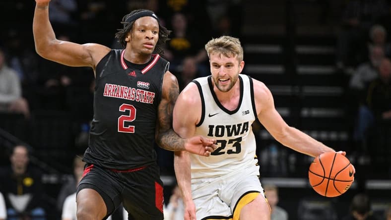 Nov 17, 2023; Iowa City, Iowa, USA; Iowa Hawkeyes forward Ben Krikke (23) controls the ball as Arkansas State Red Wolves guard Freddy Hicks (2) defends during the first half at Carver-Hawkeye Arena. Mandatory Credit: Jeffrey Becker-USA TODAY Sports