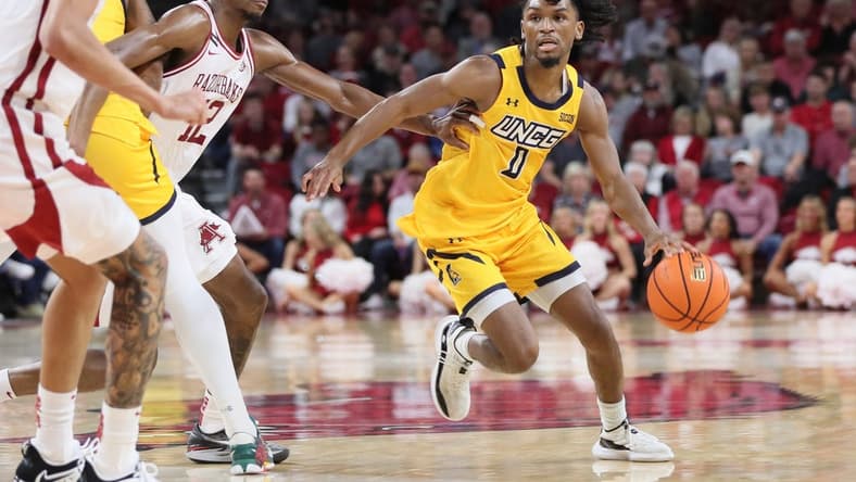 Nov 17, 2023; Fayetteville, Arkansas, USA; UNC Greensboro Spartans guard Keyshaun Langley (0) dribbles around Arkansas Razorbacks guard Truman Mark (12) during the first half at Bud Walton Arena. Mandatory Credit: Nelson Chenault-USA TODAY Sports