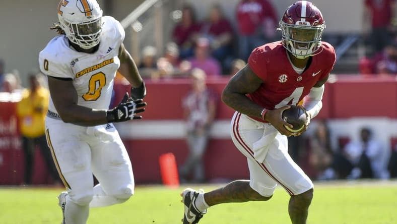 Nov 18, 2023; Tuscaloosa, Alabama, USA;  Alabama Crimson Tide quarterback Jalen Milroe (4) rolls out with Chattanooga Mocs defensive lineman Quay Wiggles (0) giving chase at Bryant-Denny Stadium. Mandatory Credit: Gary Cosby Jr.-USA TODAY Sports