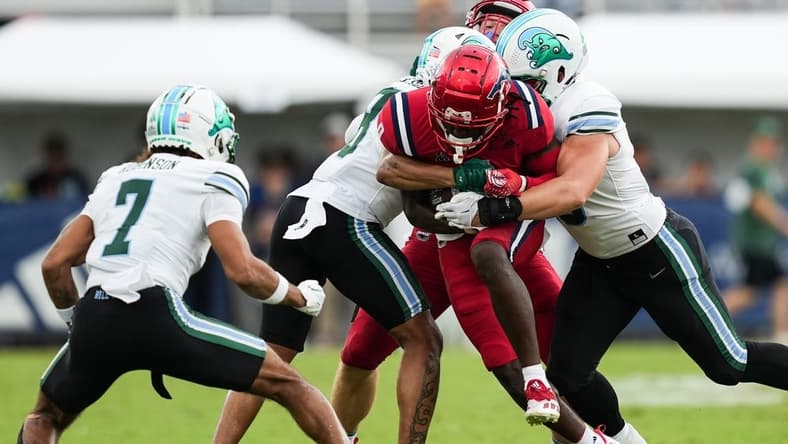 Nov 18, 2023; Boca Raton, Florida, USA; Florida Atlantic Owls wide receiver Tony Johnson (0) is tackled while running the ball against the Tulane Green Wave the first half at FAU Stadium. Mandatory Credit: Jim Rassol-USA TODAY Sports